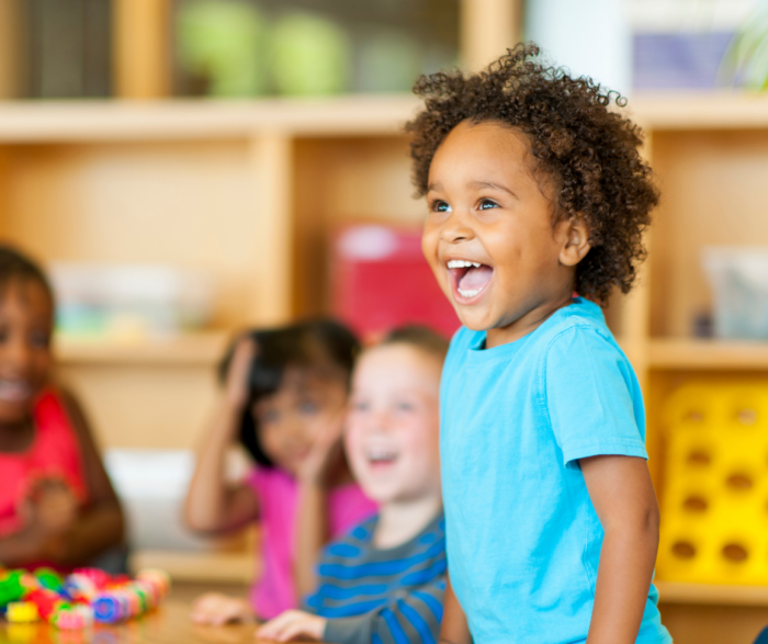 Photo of little girl in smiling in preschool classroom