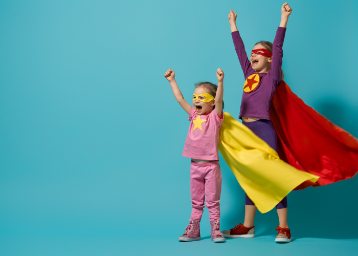 Two little girls dressed as superheroes